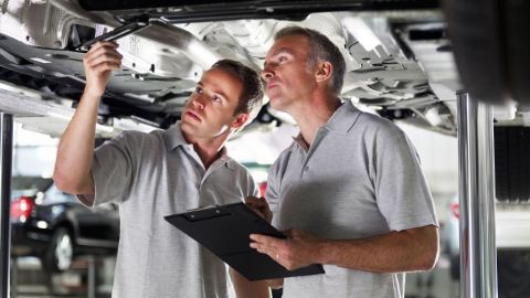 Técnicos debajo de un auto